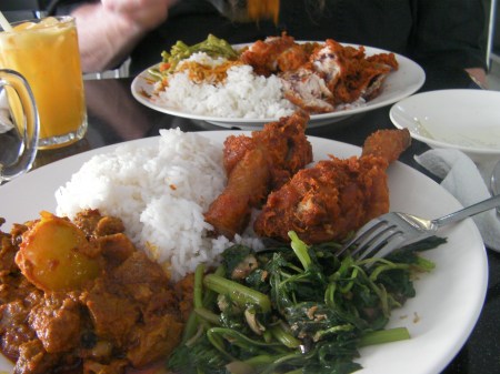 two plates of rice, chicken, lamb and vegetables