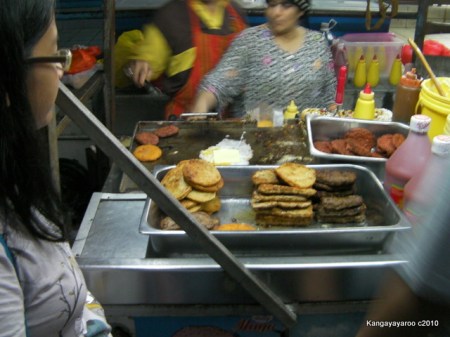 burgers being fried with egg and cheese
