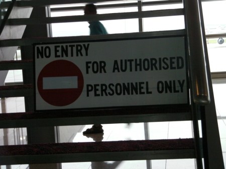 sign on stairs in airport stating "no entry for authorized personnel only"