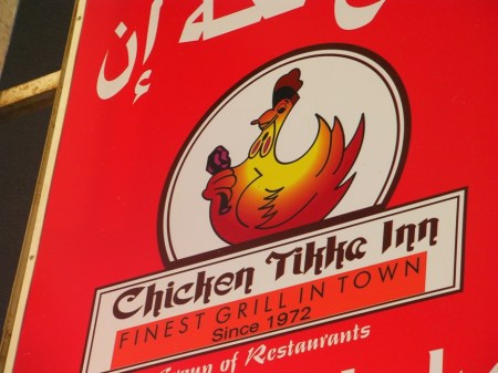 Chicken Tikke Inn Sign showing a chicken holding a drumstick
