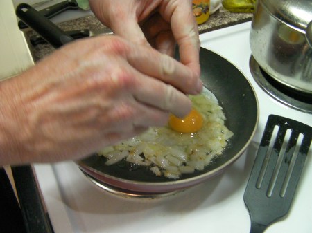 Scrambled Eggs eggs being added to sauteed onions