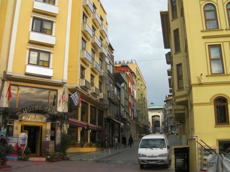 cobblestone street with yellow buildings on both sides