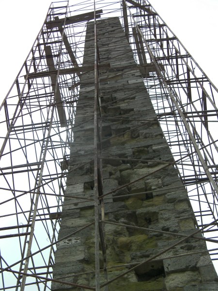 large stone column structure surrounded by scaffolding