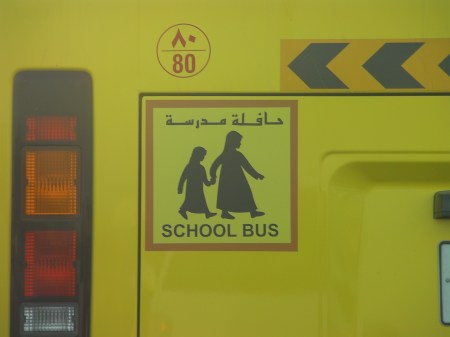 School Bus sign on school bus showing children in traditional dress