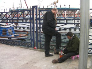 man shining another man's shoes