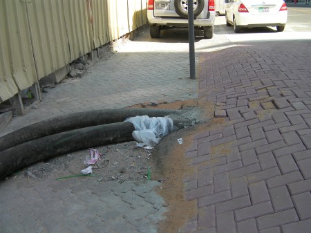 Pipes enter Speed Bump large black pipes entering side of the speed bump made of bricks