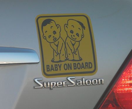 baby on board sign with two naked toddlers
