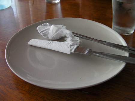 silverware wrapped in paper napkins