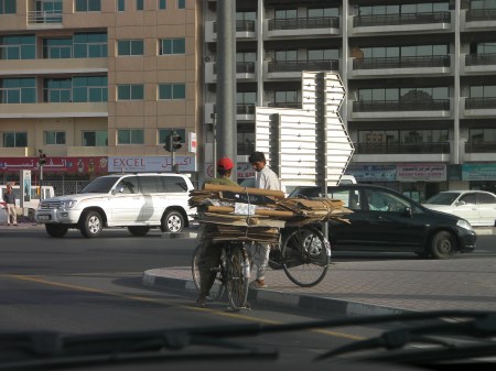 two men on bicycles loaded with flattened cardboard boxes