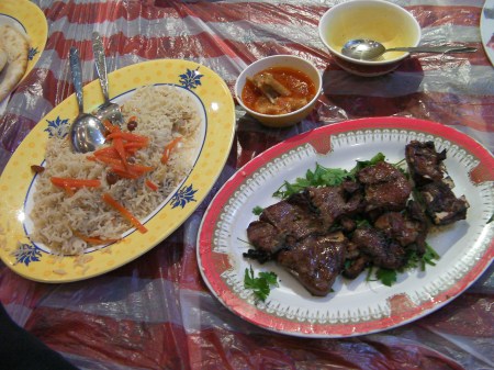 plate of rice and a plate of grilled meat