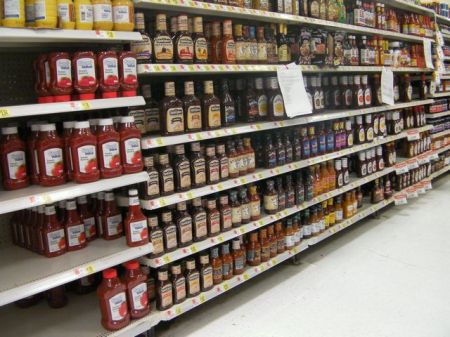 shelves full of barbecue sauce in a store
