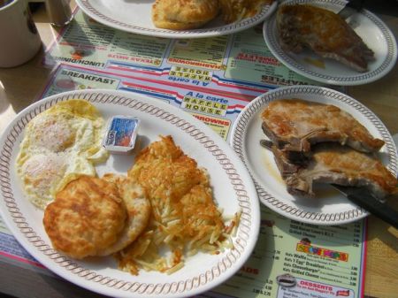 Breakfast eggs, biscuit, hash browns and two pork chops