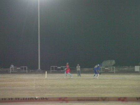 cricket players on a lit field