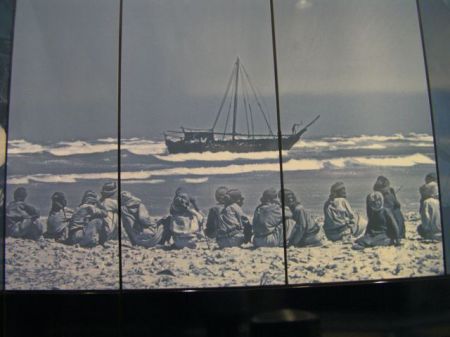 Beach Scene black and white photo of men sitting a a beach and a ship at sea