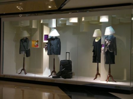 store display with manikins who have lampshades instead of heads.