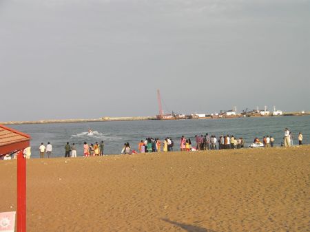 people lined up on the beach watching water skiers