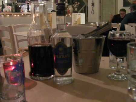 red merlot wine, bottle of ouzo, bucket of ice cubes