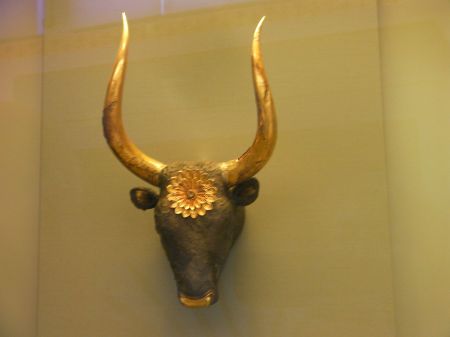 a long horn bull's head, golden horns, golden nose and a golden flower on it's forehead