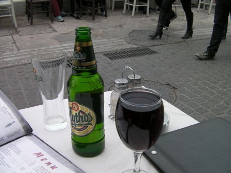 Drinks a bottle of Mythos beer and a full glass of red wine
