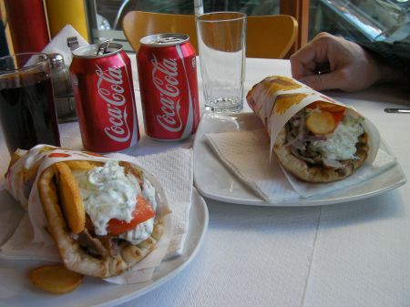 two gyro sandwiches with two Coca Colas