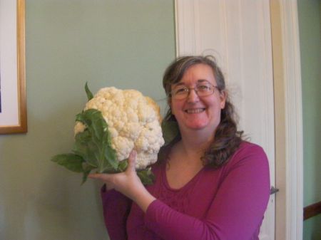 me holding the cauliflower next to my head, it is twice as large