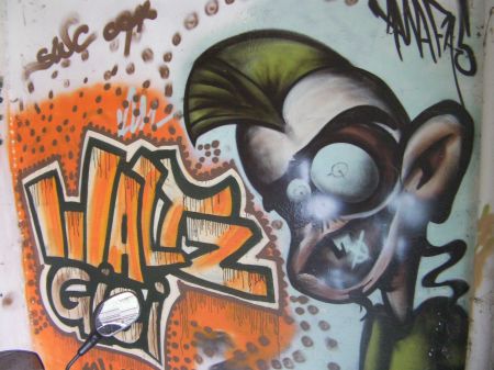 graffiti that states waltz gigi with a face with a mohawk hairdo