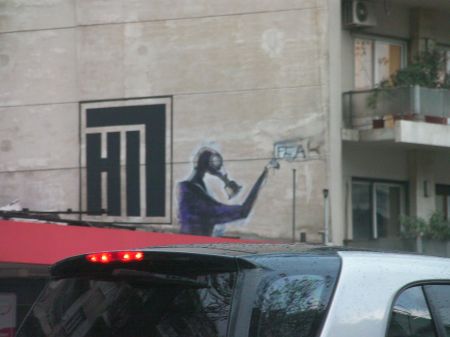 graffiti of a graffiti artist wearing a gas mask while painting the word fear