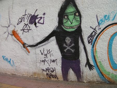 graffiti green faced guy wearing a skull and cross bones hoody carrying an orange club