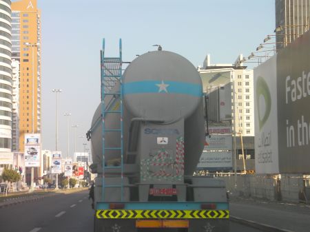 the back of a tanker truck with green and red stripe reflective tape on it