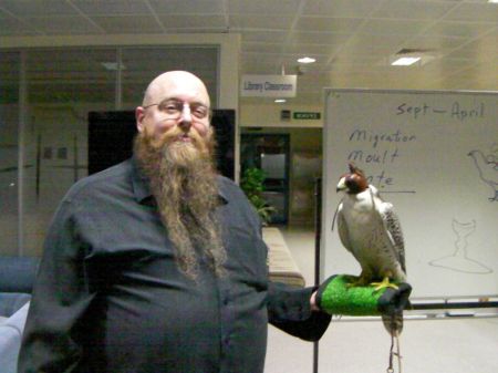 man holding a hooded falcon