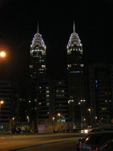 a matching pair of skyscrapers lit at night
