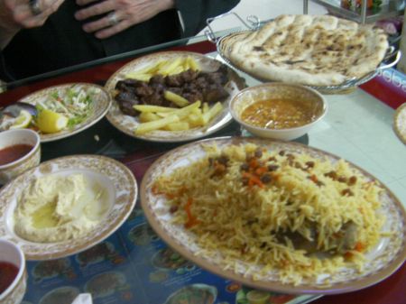Afghani Meal plates of rice, meat, salad, hummos, and bread