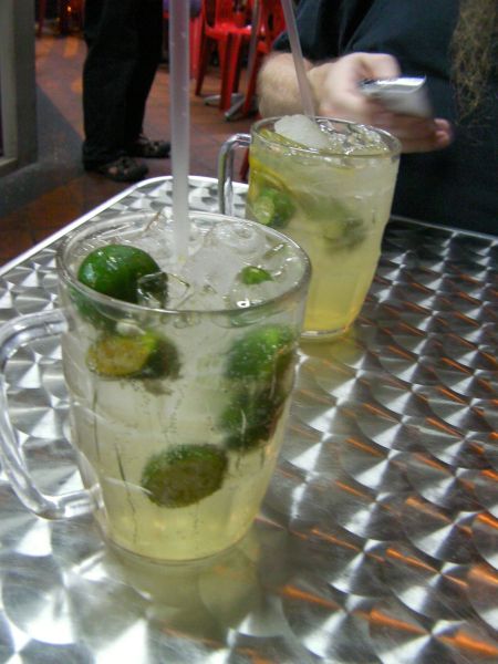 mug of soda, ice, and small limes