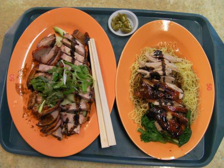 two plates filled with sliced roast pork and duck