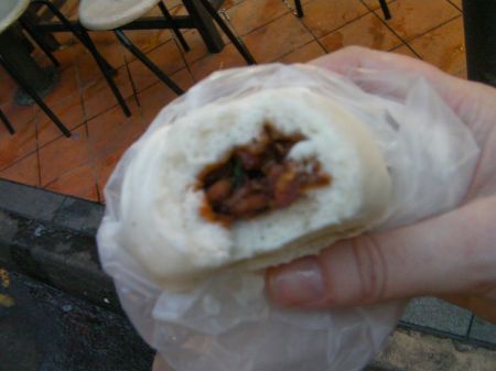 pork bun with bite taken out of it showing the filling