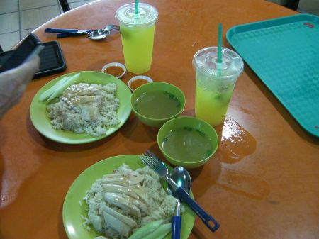two plates of rice, chicken breast, two bowls of soup, two glasses of lime juice