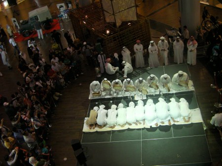 two lines of kneeling men drumming and singing