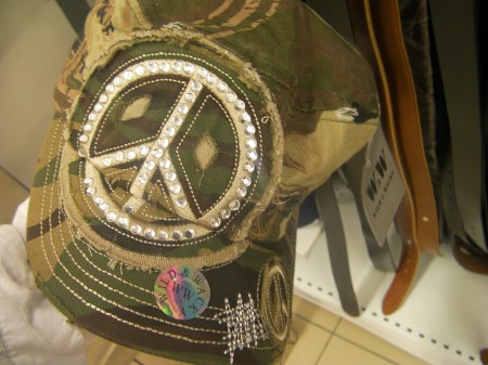 Hat baseball cap made of camouflage material with a large peace symbol made of rhinestones