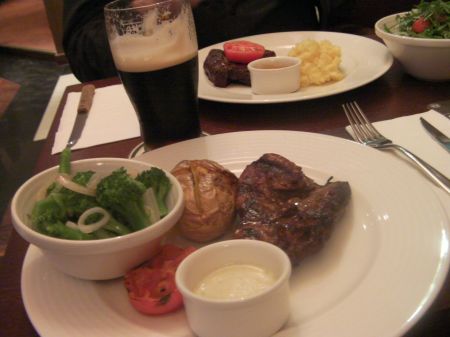 two plates of steak, mashed/baked potatoes, broccoli