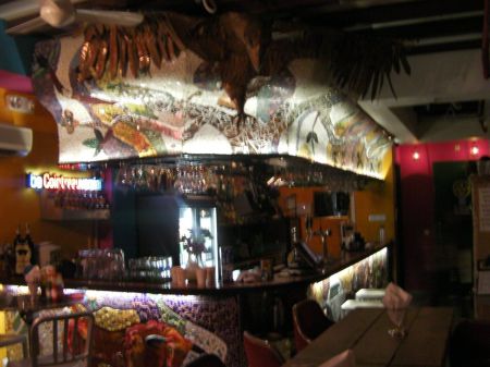 bar covered in mosaic tile work with a large bird sculpture