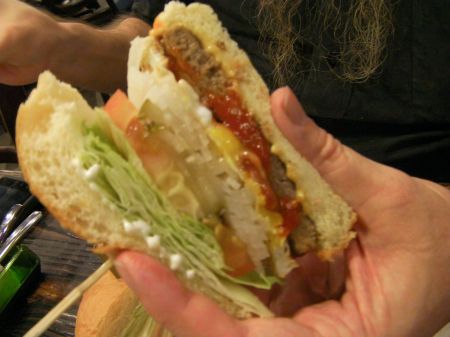 burger with a lot of fixings cut in half