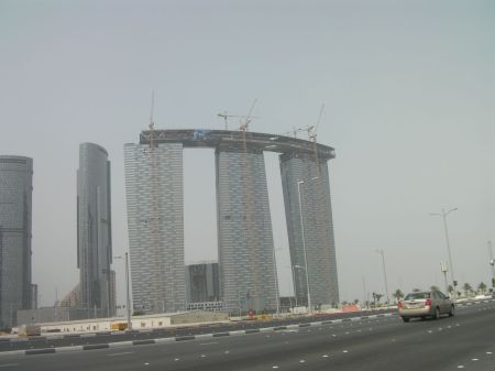 three towers under construction with a connecting structure across the top