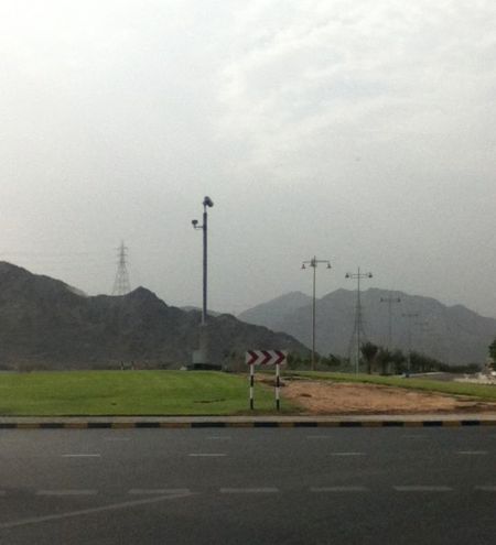 Surveillance surveillance camera on a tall pole in the center of a roundabout