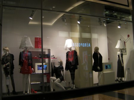 store window with manikins that have lampshades on their heads