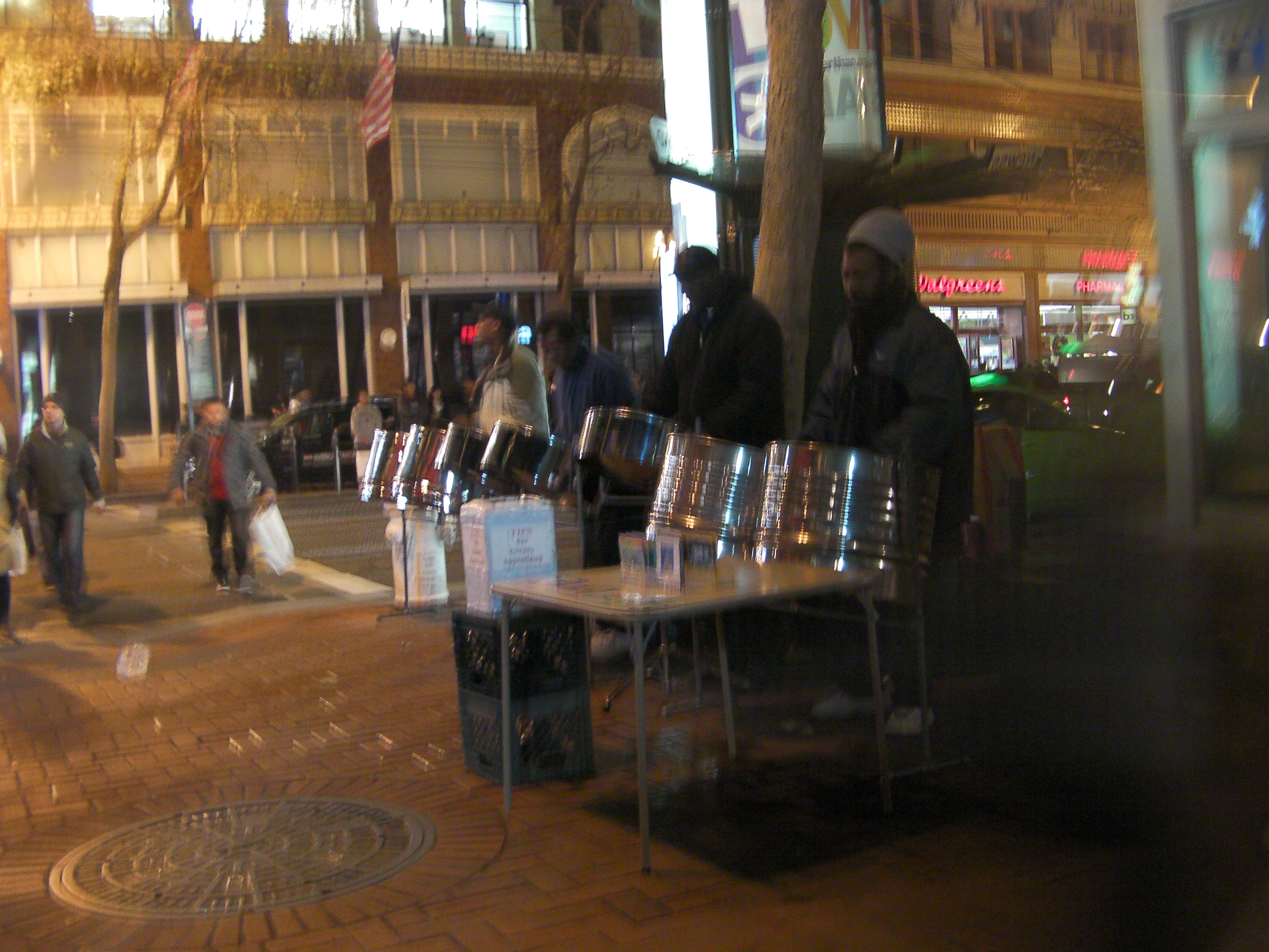 4 men playing steel drums on a street corner