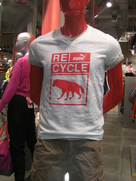 t-shirt in a shop window, Puma brand, states "recycle" and shows the silhouette of a hyena