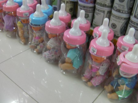 life-sized baby dolls in large plastic baby bottles