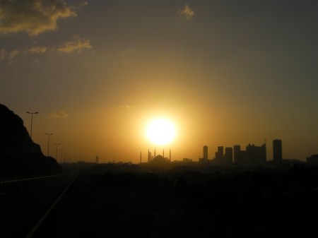 city skyline silhouetted in front of the sun