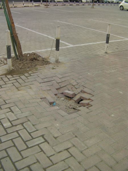a hole in brick paving caused by erosion of the sand underneath