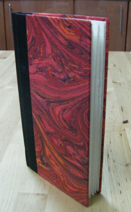 small book with black spine and red cover